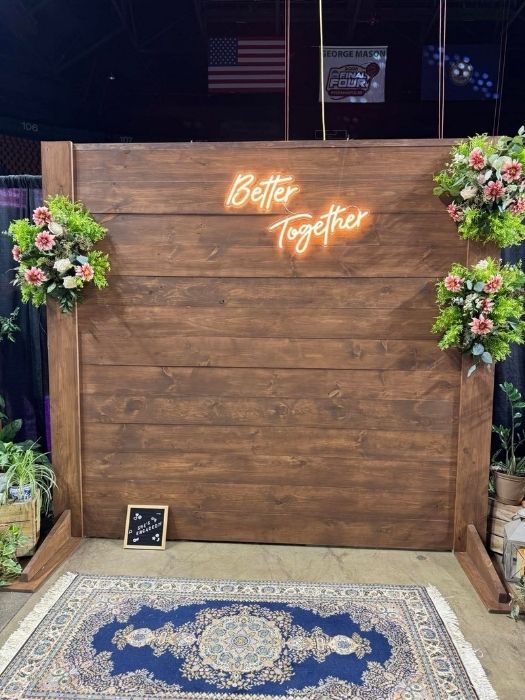 Wooden backdrop with floral accents and neon 'Better Together' sign, perfect for wedding receptions, engagement parties, or corporate events, available from Simply LaMayed.