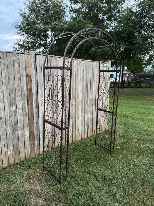 Side view of vintage-style metal arch with curved top and decorative scroll details, available for rent from Simply LaMayed Custom Decor.