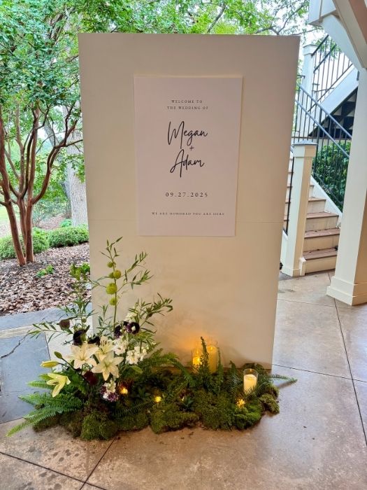 Modern white wedding welcome backdrop with greenery floral base and candles, designed and installed by Simply LaMayed for Northern Virginia weddings.