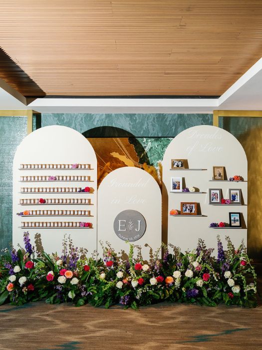 elegant triple-arch floral installation with photos and signage.
